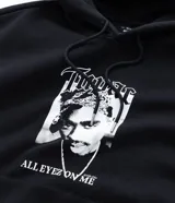 Hoodie negro de corte holgado con capucha y bolsillo frontal tipo canguro. Presenta una estampa fotográfica de Tupac Shakur en el pecho con el texto 'Tupac' y 'All Eyez On Me'.