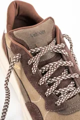 Zapatillas deportivas de cuero marrón con detalles en beige y blanco.