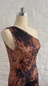 Vestido corto ajustado al cuerpo, con un solo hombro y estampado animal print en tonos marrones y negros.