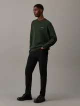 Buzo verde oscuro de algodón y poliéster con cuello redondo, puños y bajo acanalados. Presenta el logo de Calvin Klein bordado en pequeño en el pecho.