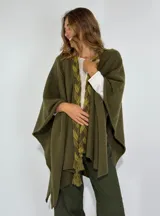 Ruana verde militar con detalle de trenza en el frente y terminaciones con flecos.