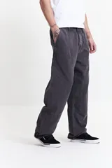 Pantalón carpenter gris oscuro de tela canvas, tiro medio y corte relajado. Cuenta con pasacintos y bolsillos tipo parche.