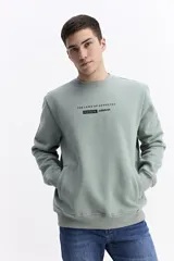 Buzo negro de algodón con cuello redondo, puños y cintura elásticos. Presenta un pequeño estampado frontal con texto en azul claro.