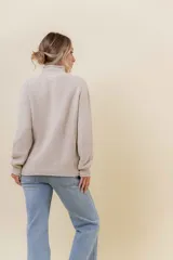Polera de tejido de punto con textura marcada, cuello alto y diseño oversize con hombros caídos y terminaciones acanaladas.
