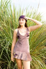 Vestido corto negro con estampado de plumas doradas, escote en V, breteles finos cruzados en la espalda, cut-outs laterales y volado en el ruedo.