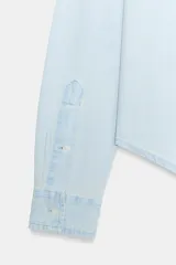 Camisa de denim en tono celeste claro, de manga larga con puños abotonados, cuello camisero clásico y cierre frontal de botones. Cuenta con el logotipo de Fruit of the Loom bordado a tono en el pecho.