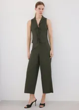 Camisa sin mangas de lino y algodón color verde militar, con cuello solapa y cierre frontal con múltiples lazos.