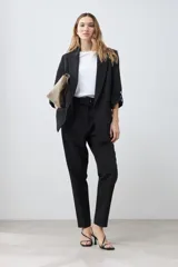 Blazer de corte recto y diseño minimalista, color blanco, con solapas clásicas, bolsillos frontales con solapa y mangas tres cuartos con detalle de botones.