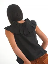 Top negro sin mangas, con escote en V profundo y detalle de apliques de tela fruncida o plisada en el frente y hombros. Se ata en el centro delantero con cintas.