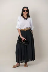 Pollera larga de color marrón, confeccionada en tela liviana con textura sutil y diseño plisado. Incluye un cinto rústico trenzado.