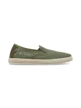 Alpargatas tipo slip-on color verde oliva, confeccionadas con materiales reciclados. Presentan un diseño con detalle bordado de espina de pescado en el lateral, refuerzo de gamuza en el talón y suela con borde de yute trenzado.