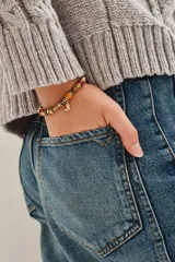 Pulsera elástica de cuentas multicolor con dije de mariposa dorada.