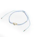 Pulsera elástica de hilo celeste con cuentas pequeñas celestes y doradas, y una perla blanca central.