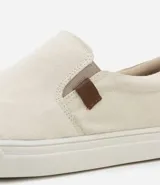 Championes tipo slip on marca Viko, de color negro con suela de goma blanca. Presenta un diseño minimalista sin cordones con paneles elásticos laterales y un pequeño detalle de etiqueta en color marrón.
