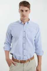 Camisa de manga larga con estampado de rayas verticales en color azul y blanco. Presenta cuello button-down, bolsillo frontal en el pecho y botones de madera.