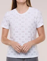 Remera blanca de calce recto con diseño de bordado calado estilo broderie, cuello redondo clásico y mangas cortas.