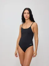 Malla entera de natación color negro con estampado de motivos playeros en blanco, con breteles finos y corte de pierna alto.