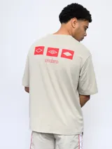 Remera de corte holgado color celeste, con cuello redondo diferenciado y logo de la marca estampado en el pecho. Presenta un diseño de manga corta y estilo deportivo.