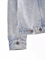 Campera de jean celeste con efecto lavado, corte recto, cuello clásico, cierre frontal con botones metálicos, bolsillos con solapa en el pecho y bolsillos laterales.