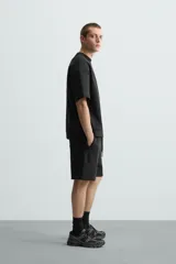 Sudadera de manga corta color marrón oscuro, con cuello redondo y bajo acabado en rib. Presenta un corte relajado y holgado (boxy fit).