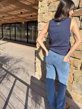 Jeans tiro medio de corte recto y calce holgado, color azul claro. Cuenta con bolsillos delanteros decorados con flecos de gamuza marrón.