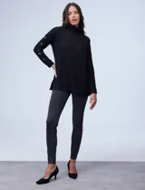 Polera negra de tejido soft con cuello alto y mangas largas con aplique de botones.