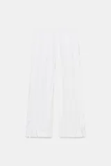 Pantalón ancho de tiro alto color azul marino, con cintura elástica fruncida y bolsillos delanteros. El bajo de las piernas tiene un detalle de lazada o puño vuelto.