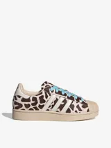 Championes Adidas Superstar II con diseño de estampado animal print tipo vaca, puntera de goma clásica, tres tiras laterales blancas y cordones en color celeste.