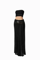 Conjunto de dos piezas compuesto por un top corto tipo strapless con detalle de aberturas en el ruedo y una falda larga de tiro medio con transparencias, aberturas en la cintura y cinturón incorporado con tachas y hebilla metálica.