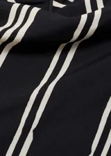 Vestido midi de diseño asimétrico con estampado de rayas verticales blancas sobre fondo negro. Presenta cuello perkins, mangas cortas y tejido fluido con acabado satinado.