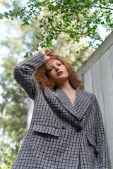 Blazer de paño con estampa a cuadros en tonos marrones y beige, de corte recto y mangas largas.