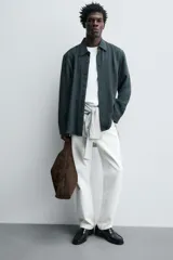 Bolso de hombro marrón con efecto serraje. Tiene un compartimento principal con cierre magnético y un bolsillo interior con cremallera. El asa es del mismo material.