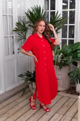 Camisola larga roja, tipo vestido camisero, con cuello y botones frontales. Presenta mangas cortas y aberturas laterales en el ruedo.