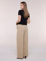 Cardigan corto de tejido de punto fino con hilo brillante de lurex y destellos metalizados. Presenta escote en V pronunciado, mangas cortas, cierre frontal con botones a tono y ruedo con terminación en pico en el frente.