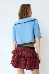 Short pollera de sarga en mezcla de viscosa con estampado geométrico en tonos bordó y blanco. Presenta cintura ancha fruncida y diseño escalonado con volados.