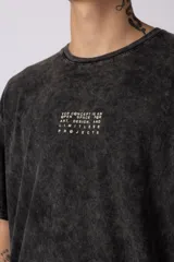 Remera gris de corte oversize con efecto acid wash y estampa pequeña en el pecho.