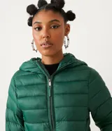 Campera puffer roja, ligera, de poliamida, con capucha y bolsillos con cremallera. Incluye bolsa para guardarla.