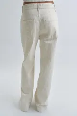 Jeans de tiro alto y corte wide leg, confeccionados en tejido de algodón con diseño de rayas verticales a contraste. Presentan cinco bolsillos, trabillas en la cintura y cierre frontal con cremallera y botón.