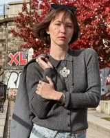 Collar con dije grande de bronce con forma orgánica y textura rugosa, suspendido de un cordón negro. Incluye cordones intercambiables.