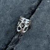 Anillo ancho de diseño orgánico y calado, con apariencia de red o magma solidificado.