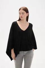 Poncho negro de tejido de punto con escote en V, diseño asimétrico y corte holgado.