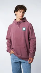 Hoodie de color rosa viejo con capucha y cordones ajustables. Presenta un bolsillo frontal tipo canguro y un parche cuadrado en el pecho con un diseño de una cruz blanca sobre fondo verde.