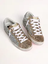 Zapatillas Golden Goose modelo Super-Star, cubiertas de glitter plateado y dorado.