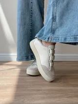 Zapatillas blancas de cuero con detalles en cuero gamuzado color beige en la puntera y ajuste con velcro. Presenta detalle de cuero con estampado reptil en el talón.