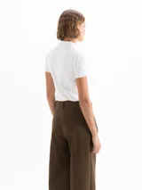 Remera de manga corta con cuello tipo polo, confeccionada en algodón pima con elastano. Presenta un diseño de calce regular con largo a la primera cadera y logo bordado en la espalda.