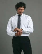 Camisa de vestir blanca de corte clásico, con cuello rígido y mangas largas con puños abotonados.