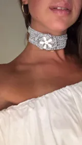 Gargantilla choker color plateado, tejida en hilo brillante, con aplique de flor de canutillos.