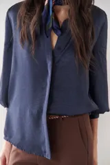Camisa azul marino de satén con cuello clásico, cierre frontal con botones y mangas largas con puños abotonados.