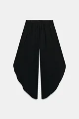 Pantalón fluido de tiro alto en color blanco, con pinzas delanteras, cintura elástica en la espalda y perneras anchas con aberturas laterales pronunciadas.