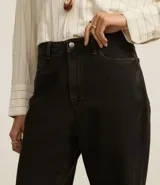 Pantalón wide leg negro de sarga de algodón, con cintura alta, trabillas, bolsillos delanteros y traseros, y cierre con botón y cremallera.